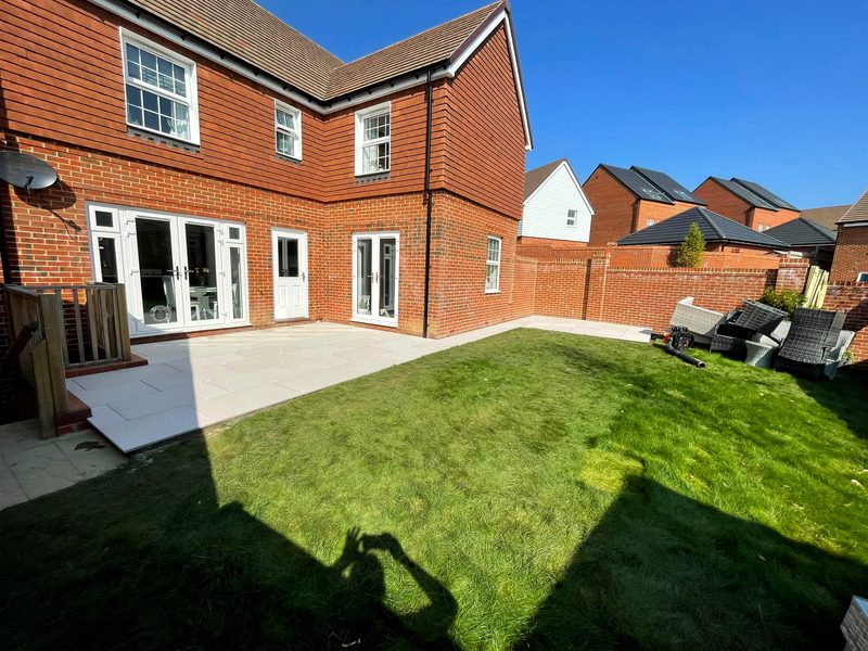 Landscaped garden and lawn behind a large house
